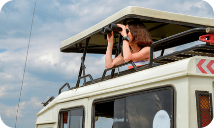 Tourist spotting wildlife from a safari vehicle in Kenya