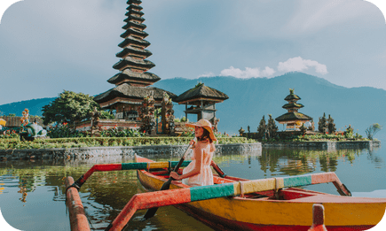 Traveler in traditional boat at Pura Ulun Danu Beratan, Bali.